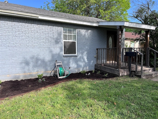 exterior space featuring a lawn and brick siding