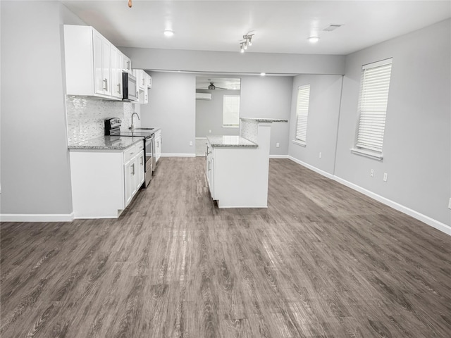 kitchen featuring a ceiling fan, a sink, white cabinetry, decorative backsplash, and appliances with stainless steel finishes