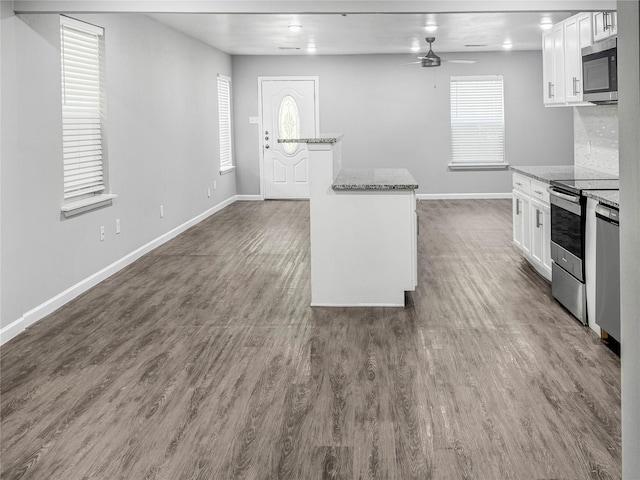 kitchen featuring a ceiling fan, light stone countertops, baseboards, white cabinets, and appliances with stainless steel finishes
