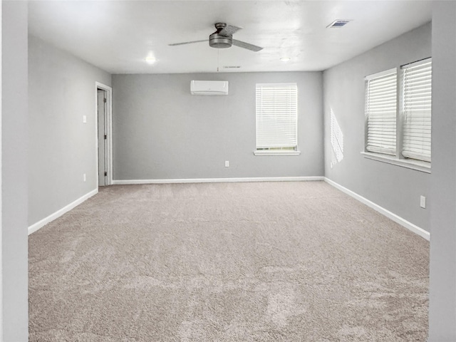 unfurnished room with ceiling fan, visible vents, a wall unit AC, and carpet floors