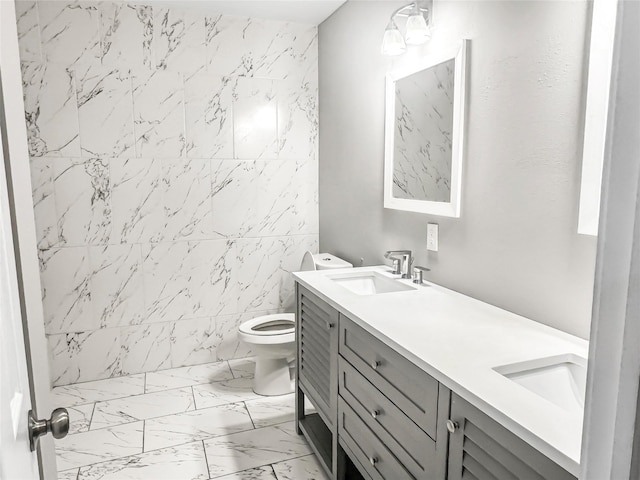 bathroom featuring double vanity, toilet, marble finish floor, and a sink