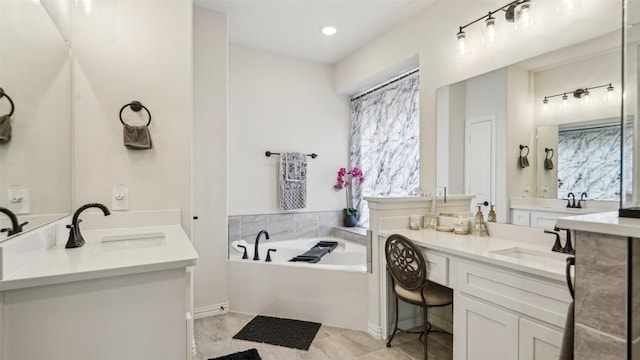 full bath featuring a bath, two vanities, and a sink
