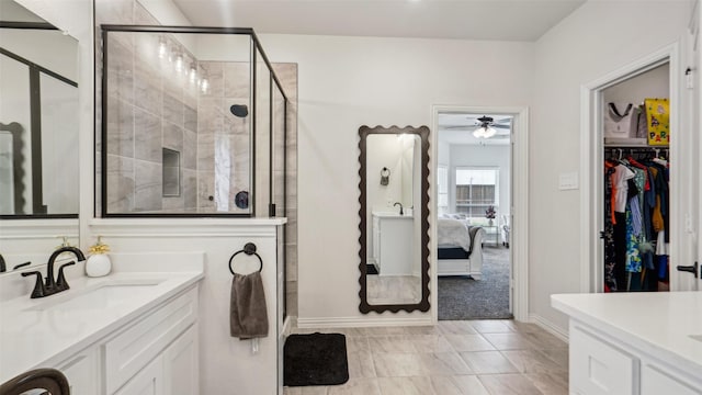 ensuite bathroom featuring a stall shower, a ceiling fan, baseboards, vanity, and connected bathroom