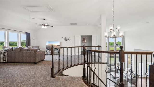 hall featuring attic access, an upstairs landing, visible vents, vaulted ceiling, and carpet flooring
