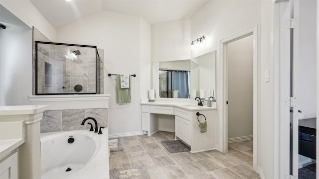 1106 Alaska Dr, Forney, TX 75126 - bathroom with vanity, a garden tub, a tile shower, vaulted ceiling, and baseboards