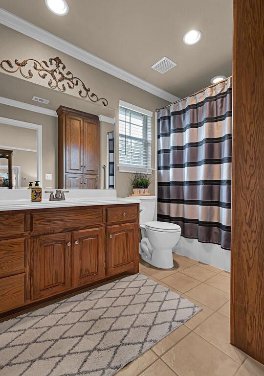 bathroom featuring toilet, tile patterned floors, visible vents, vanity, and ornamental molding