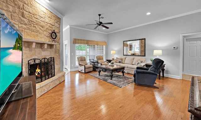 living room featuring a ceiling fan, baseboards, crown molding, wood finished floors, and a fireplace