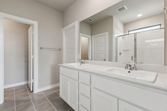 bathroom with a sink, double vanity, a stall shower, and visible vents