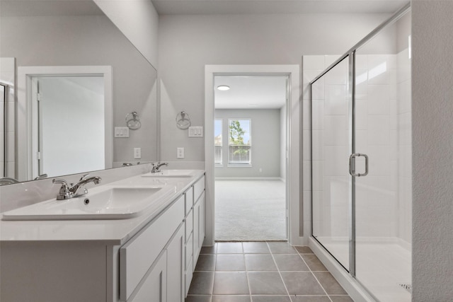 bathroom featuring double vanity, tile patterned flooring, a shower stall, and a sink