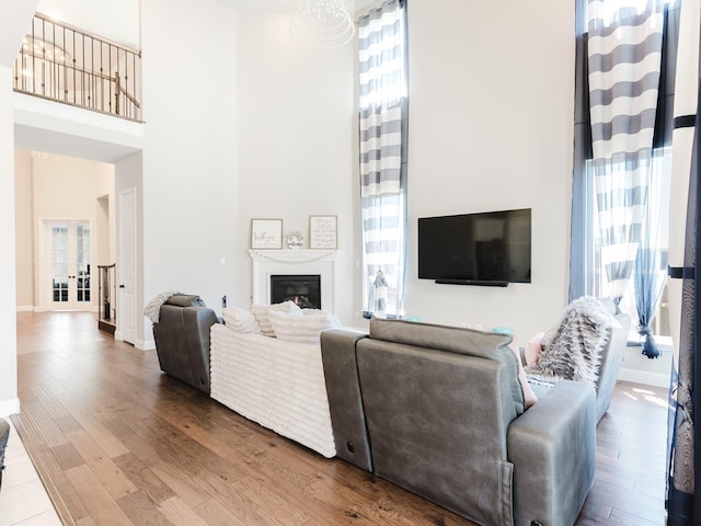 5932 Folsum Pl, Mckinney, TX 75070 - living room with a towering ceiling, baseboards, a glass covered fireplace, and wood finished floors