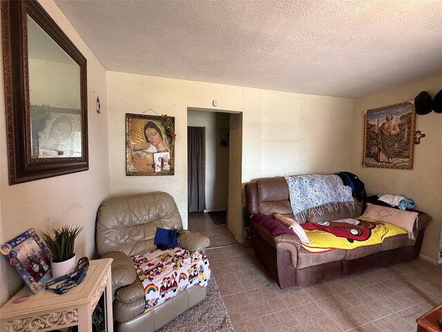 tiled living room featuring a textured ceiling
