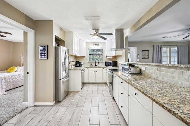 1015 Van Winkle St, Weatherford, TX 76086 - kitchen with a ceiling fan, appliances with stainless steel finishes, extractor fan, light stone counters, and white cabinetry