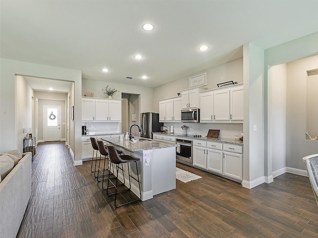 1455 Radecke Rd, Krum, TX 76249 - kitchen featuring stainless steel appliances, a sink, a kitchen breakfast bar, dark wood-style flooring, and recessed lighting