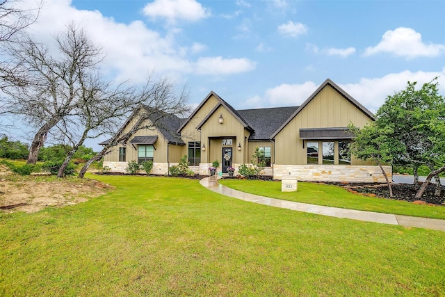 modern farmhouse style home with roof with shingles, a front lawn, stone siding, and board and batten siding