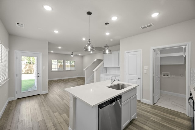 216 Griffith, Princeton, TX 75407 - kitchen with stainless steel dishwasher, a sink, light countertops, white cabinets, and light wood-style floors