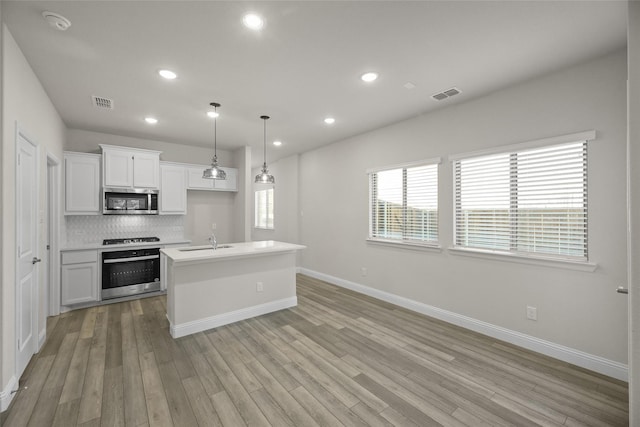 216 Griffith, Princeton, TX 75407 - kitchen with stainless steel microwave, oven, a sink, light wood-style floors, and recessed lighting