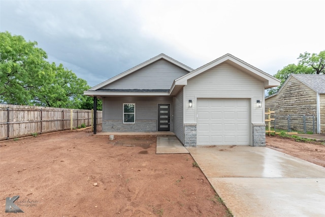 ranch-style house with concrete driveway, fence, and a garage