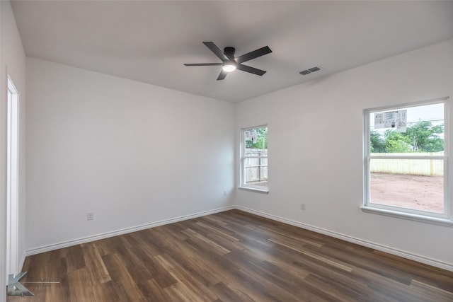 unfurnished room with visible vents, dark wood-style flooring, baseboards, and ceiling fan