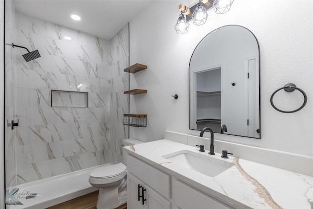 bathroom featuring walk in shower, toilet, and vanity