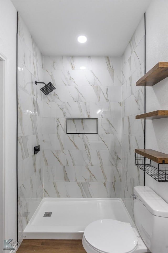 bathroom with toilet and a tile shower