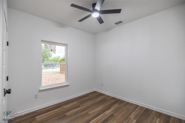 spare room with baseboards, ceiling fan, visible vents, and dark wood-type flooring