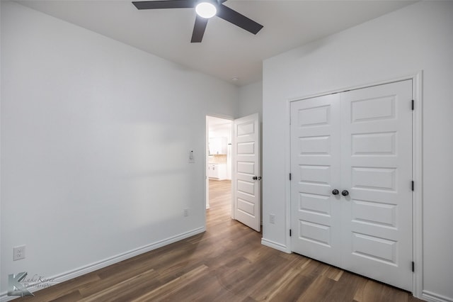 unfurnished bedroom featuring a ceiling fan, a closet, dark wood-type flooring, and baseboards