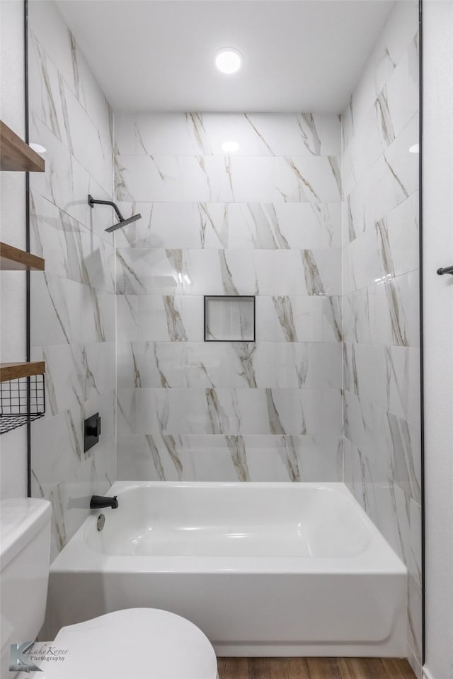 full bath with toilet, shower / washtub combination, and wood finished floors