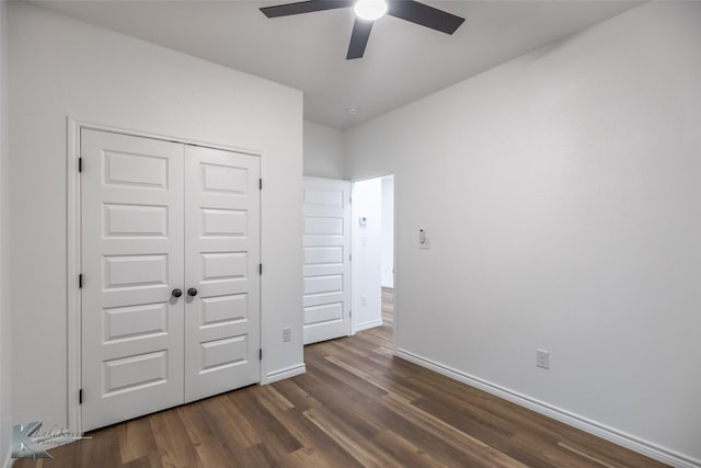 unfurnished bedroom with baseboards, dark wood-style flooring, a closet, and a ceiling fan