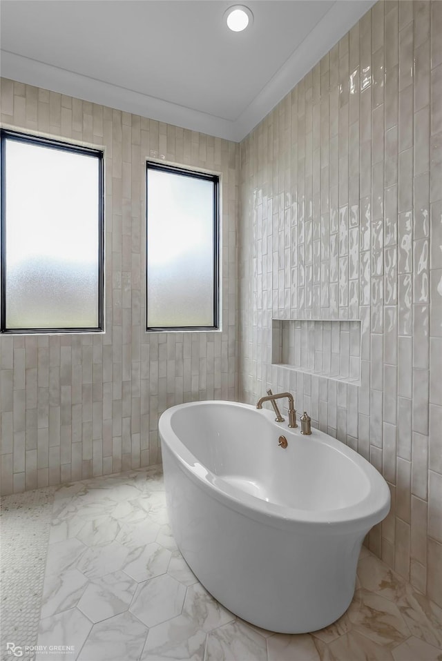 full bath featuring marble finish floor and a freestanding tub