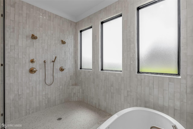 full bath featuring a soaking tub and tiled shower