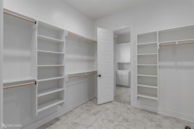 spacious closet featuring marble finish floor