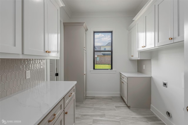 washroom featuring cabinet space, baseboards, and electric dryer hookup