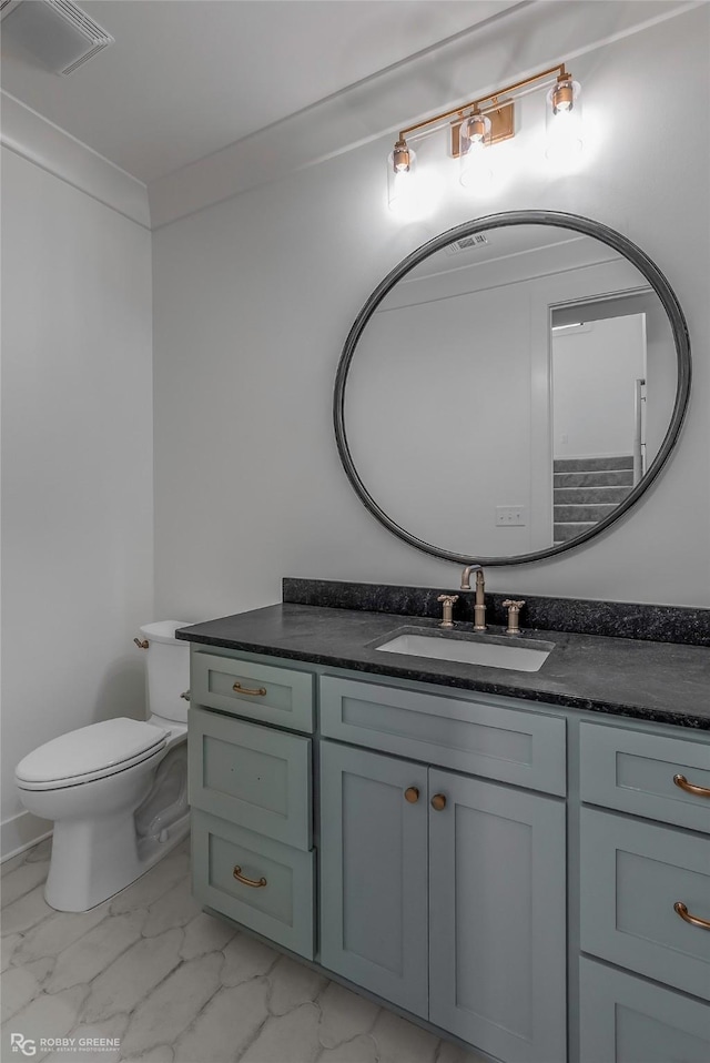 bathroom featuring toilet, visible vents, marble finish floor, and vanity