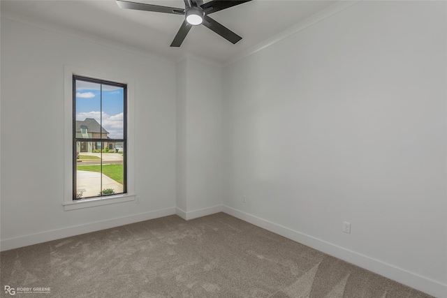 carpeted spare room with baseboards, ornamental molding, and ceiling fan