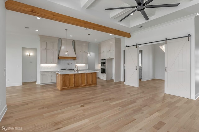kitchen featuring beam ceiling, a barn door, recessed lighting, backsplash, and custom range hood