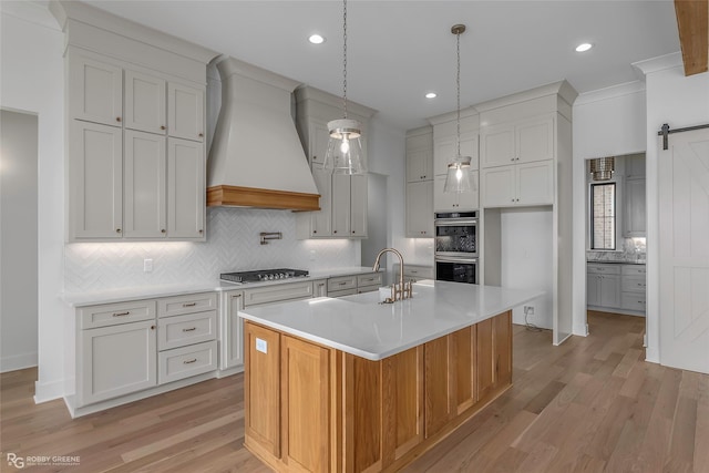 kitchen featuring a sink, double oven, light countertops, decorative backsplash, and custom range hood