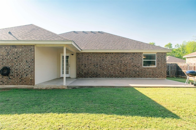 back of house featuring a patio area, brick siding, and a shingled roof