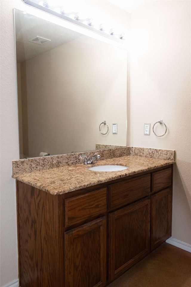 bathroom featuring visible vents, baseboards, and vanity