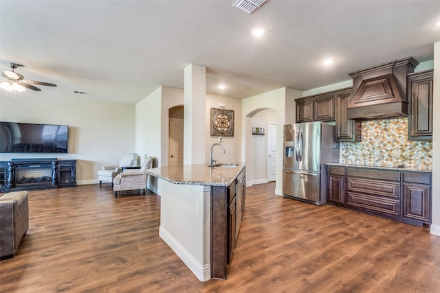 3530 Beaumont Dr, Wylie, TX 75098 - kitchen featuring stainless steel refrigerator with ice dispenser, arched walkways, open floor plan, premium range hood, and a sink