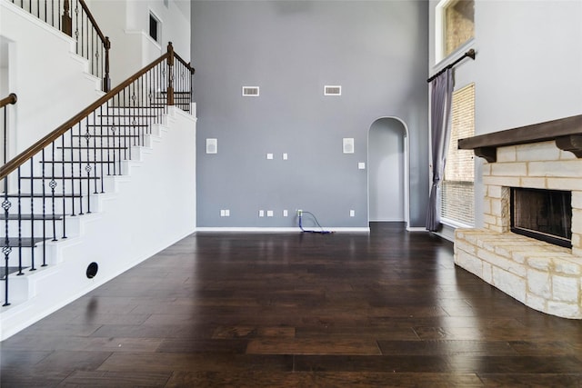 1112 Crest Ridge Dr, Glenn Heights, TX 75154 - unfurnished living room with a high ceiling, arched walkways, wood finished floors, baseboards, and stairs