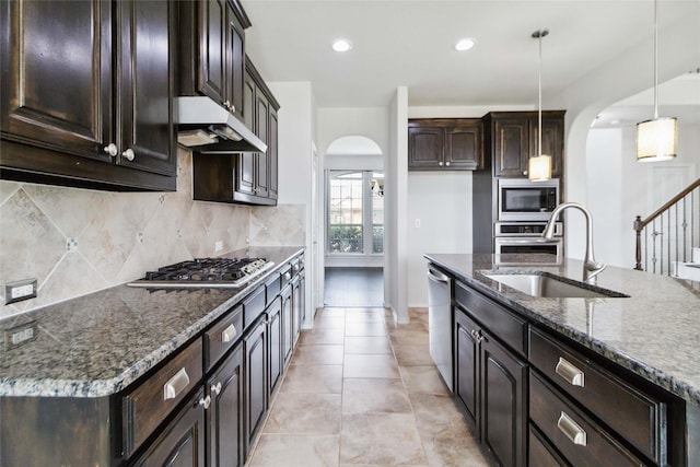1112 Crest Ridge Dr, Glenn Heights, TX 75154 - kitchen with arched walkways, a sink, stainless steel appliances, dark stone countertops, and tasteful backsplash