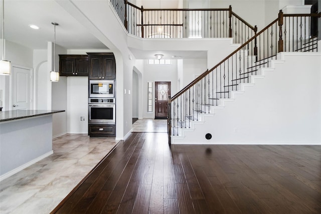1112 Crest Ridge Dr, Glenn Heights, TX 75154 - foyer entrance featuring baseboards, hardwood / wood-style floors, stairs, a high ceiling, and arched walkways