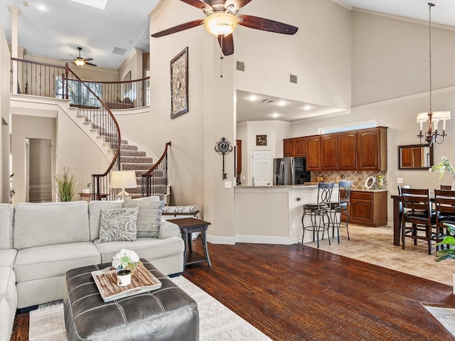 4308 Echo Bluff Dr, Plano, TX 75024 - living area with ceiling fan, a towering ceiling, stairway, a chandelier, and ornamental molding