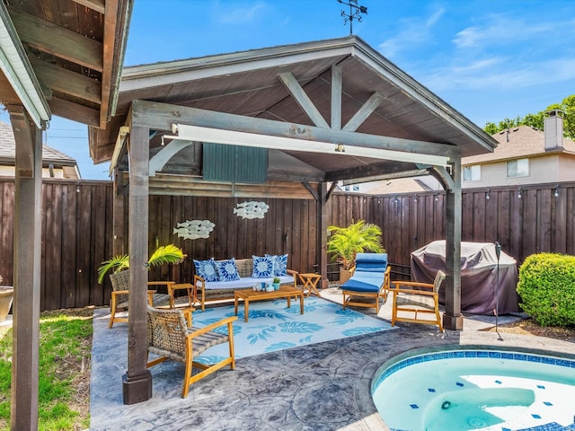 view of patio with area for grilling, a fenced backyard, a gazebo, and an outdoor living space