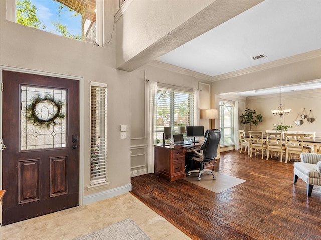 foyer entrance featuring an inviting chandelier, ornamental molding, and visible vents