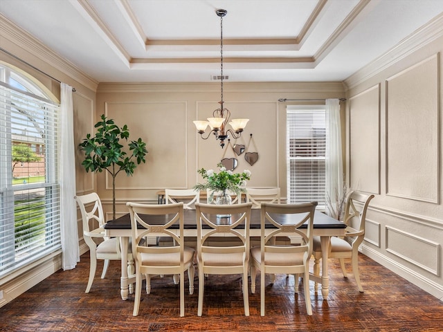 dining room featuring a decorative wall, visible vents, dark wood finished floors, a chandelier, and a raised ceiling