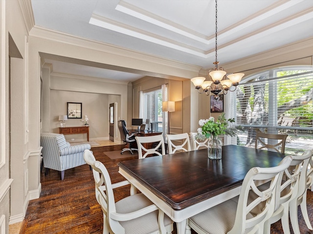 dining area featuring crown molding, a raised ceiling, a notable chandelier, and wood finished floors