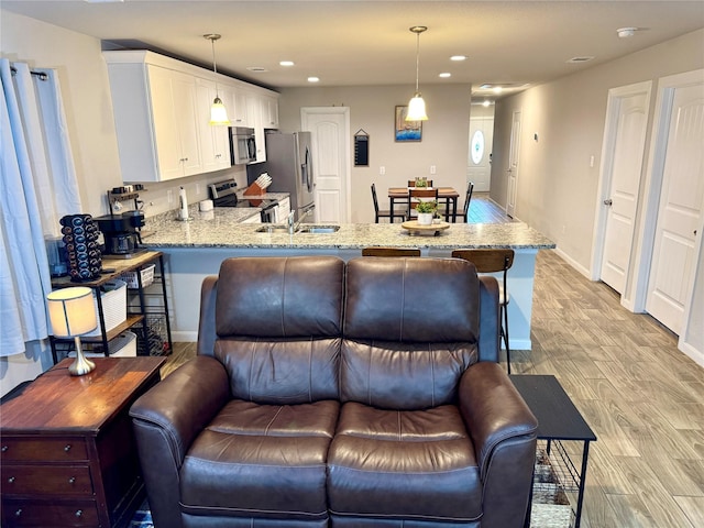 124 Oakwood St, Chico, TX 76431 - kitchen with light wood-type flooring, recessed lighting, light stone countertops, and appliances with stainless steel finishes