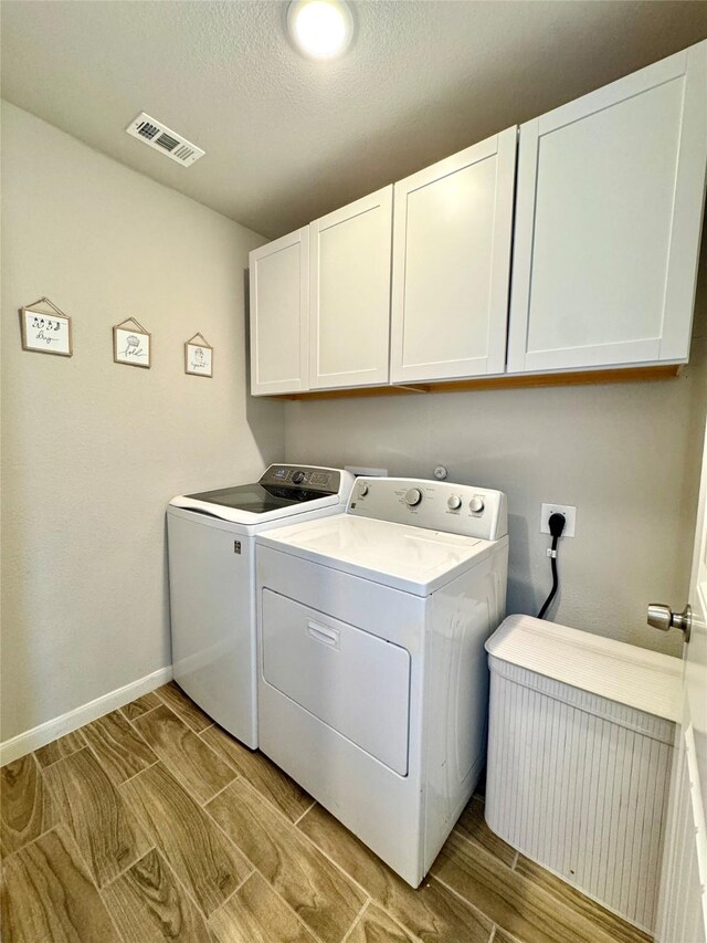 124 Oakwood St, Chico, TX 76431 - laundry room featuring washing machine and dryer, cabinet space, baseboards, and visible vents