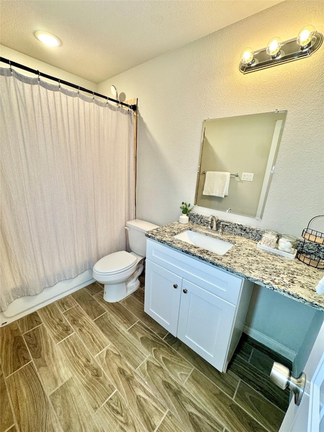 124 Oakwood St, Chico, TX 76431 - bathroom with toilet, shower / tub combo, wood tiled floor, a textured ceiling, and vanity